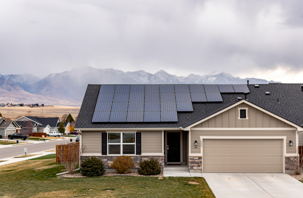 Rooftop solar panels on a home under an overcast sky.